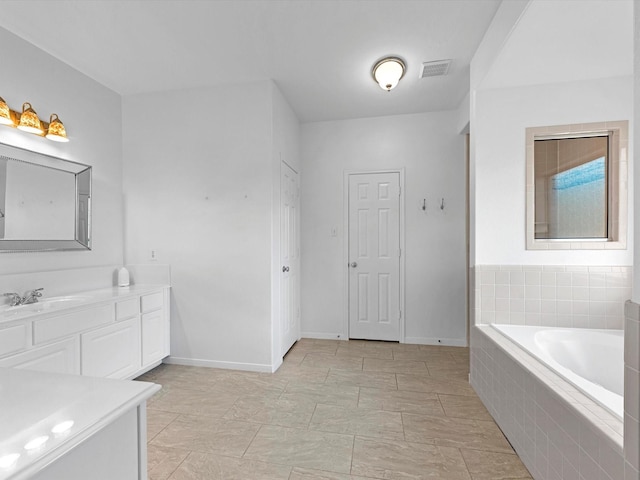 bathroom with vanity and a relaxing tiled tub