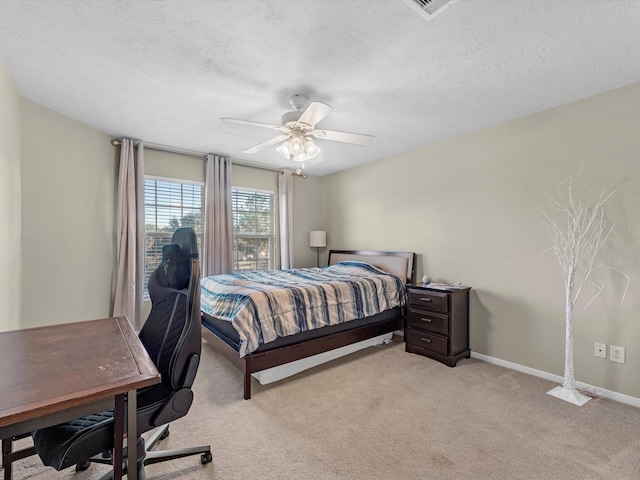 carpeted bedroom featuring ceiling fan and a textured ceiling