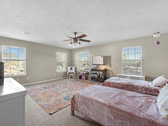 carpeted bedroom featuring multiple windows, a textured ceiling, and ceiling fan