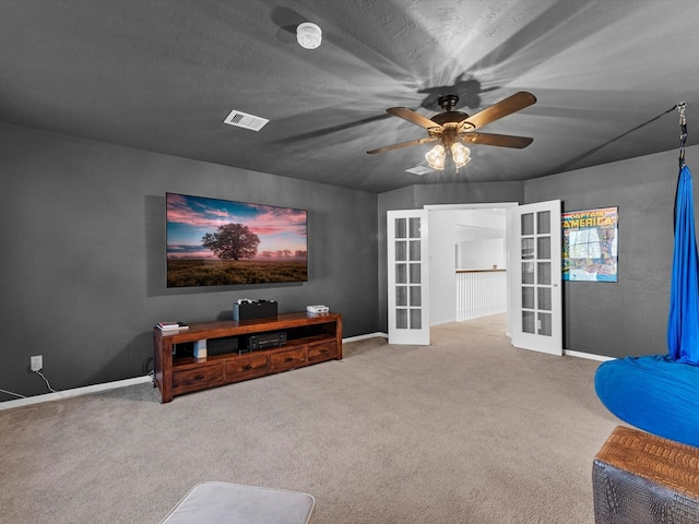 living room with ceiling fan, light colored carpet, a textured ceiling, and french doors