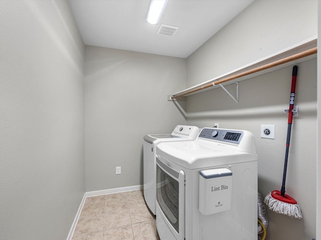 washroom featuring washing machine and dryer and light tile patterned flooring