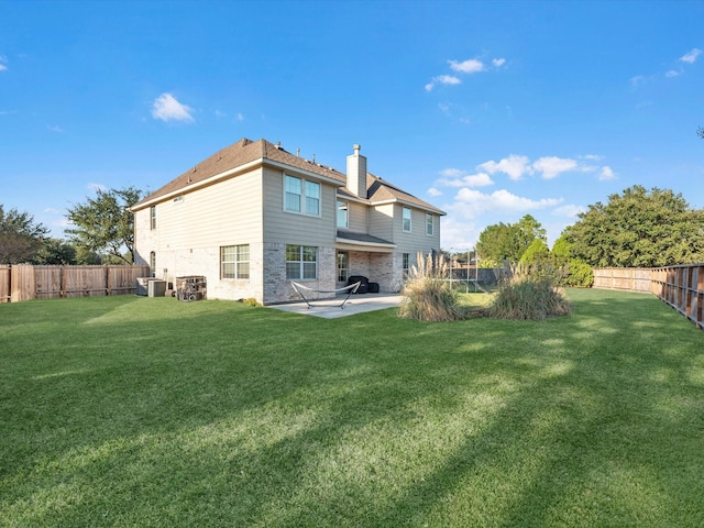 rear view of house featuring a lawn, cooling unit, and a patio