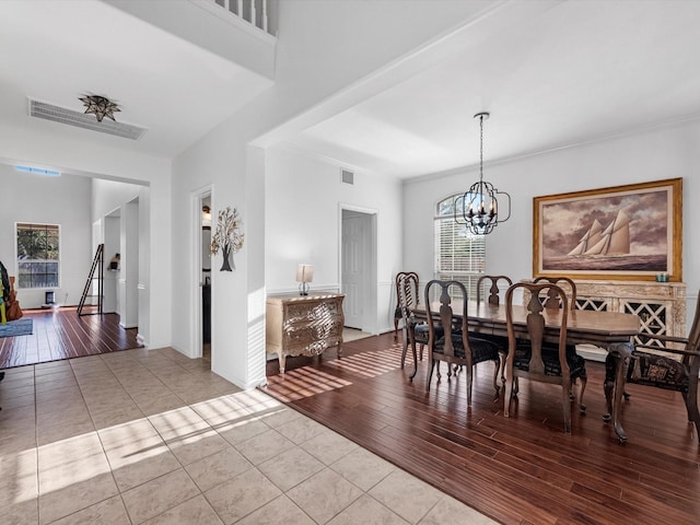 dining space featuring a chandelier, ornamental molding, and light hardwood / wood-style flooring