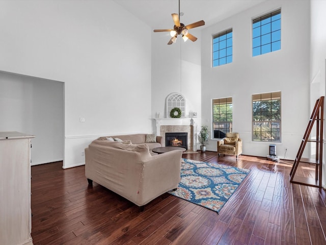 living room featuring a high ceiling, dark hardwood / wood-style floors, and ceiling fan