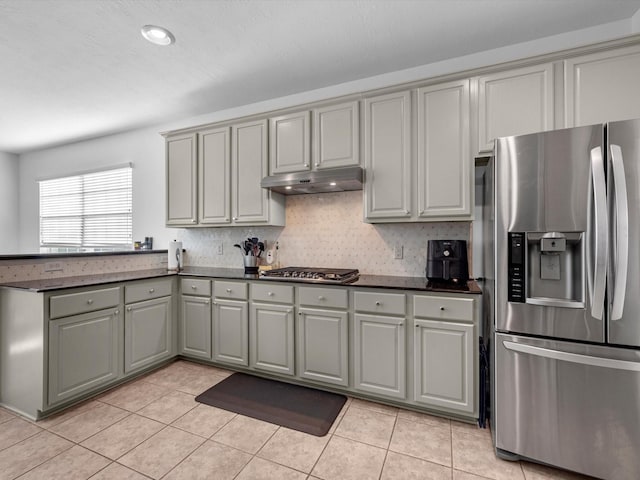 kitchen featuring backsplash, gray cabinets, light tile patterned floors, and stainless steel appliances