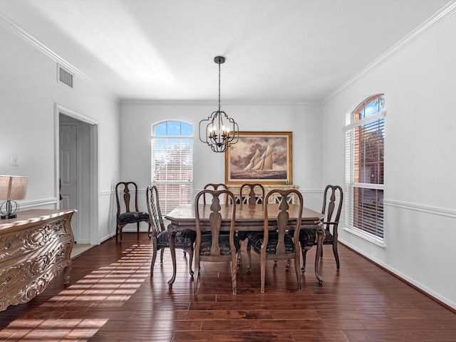 dining space with ornamental molding, plenty of natural light, dark wood-type flooring, and a notable chandelier