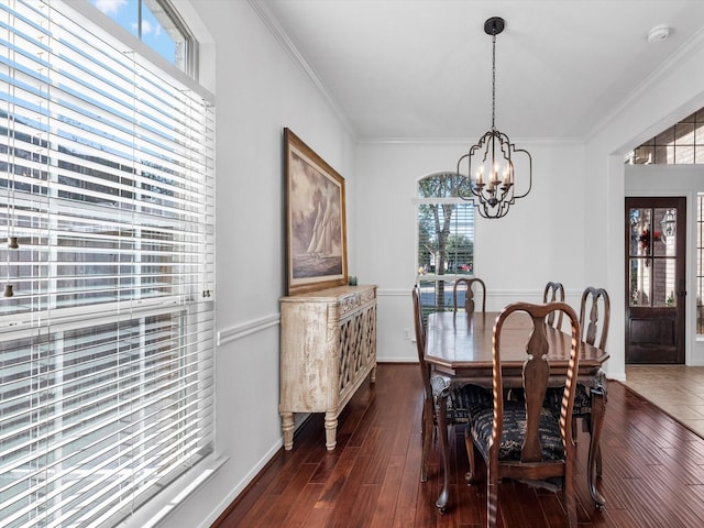 dining area with a notable chandelier, dark hardwood / wood-style floors, crown molding, and a wealth of natural light