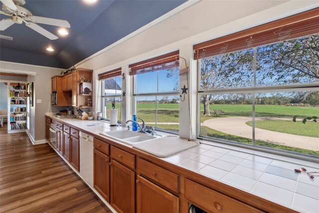 kitchen featuring tile counters, sink, dark hardwood / wood-style flooring, white dishwasher, and vaulted ceiling