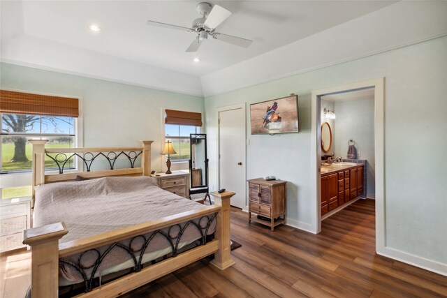 bedroom with ensuite bath, ceiling fan, multiple windows, and dark hardwood / wood-style floors