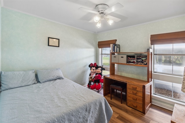 bedroom with hardwood / wood-style flooring, ceiling fan, and crown molding