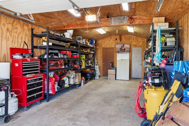 garage with a garage door opener and wood walls