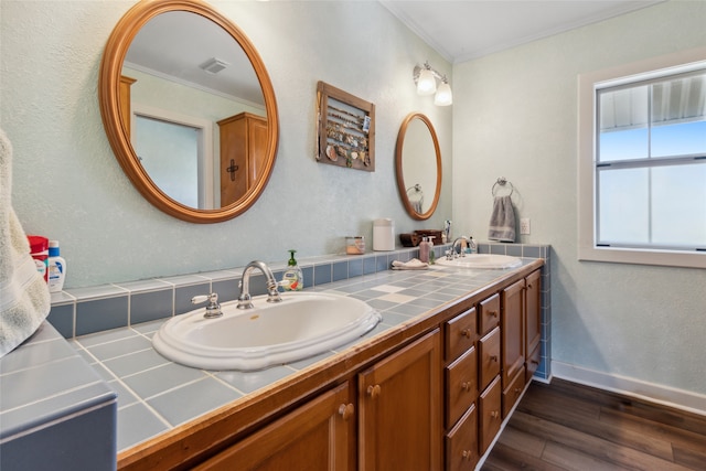 bathroom with wood-type flooring, vanity, and crown molding