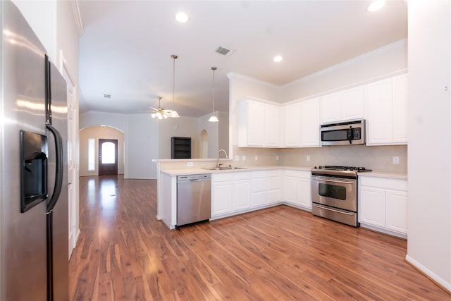 kitchen featuring hardwood / wood-style floors, stainless steel appliances, and white cabinetry