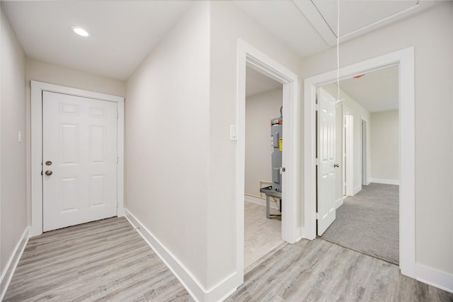 hall featuring electric water heater and light hardwood / wood-style floors