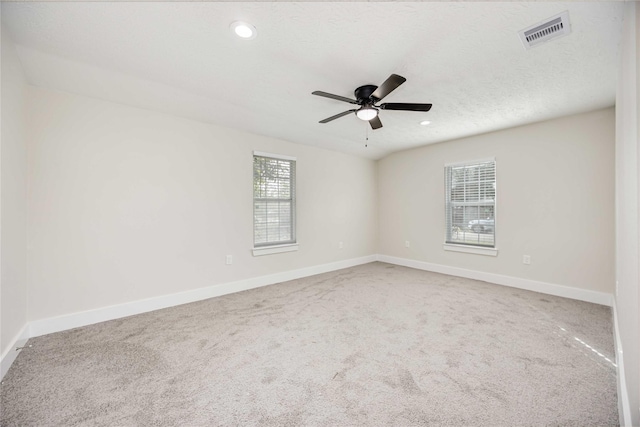 carpeted empty room with ceiling fan and a textured ceiling