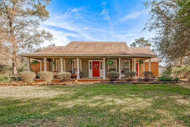 view of front facade featuring a porch, brick siding, and a front lawn