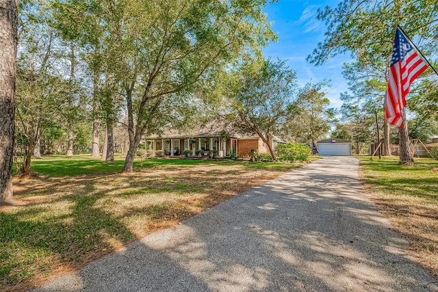 view of front of home with a front yard, covered porch, and an outdoor structure