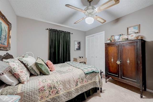 carpeted bedroom featuring ceiling fan, a closet, and a textured ceiling