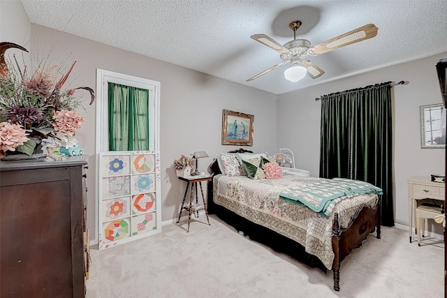 bedroom with a textured ceiling, light colored carpet, and ceiling fan