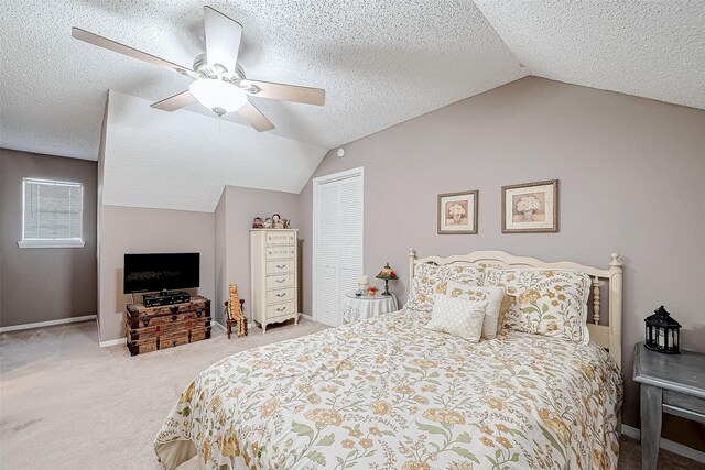 carpeted bedroom featuring ceiling fan, lofted ceiling, a textured ceiling, and a closet