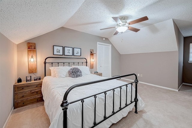 carpeted bedroom featuring ceiling fan, lofted ceiling, a textured ceiling, and a closet