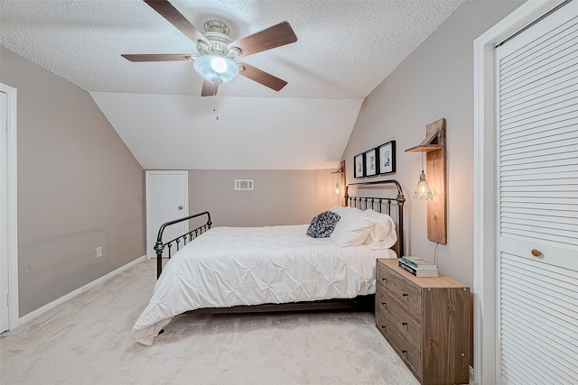 carpeted bedroom featuring ceiling fan, a closet, a textured ceiling, and vaulted ceiling