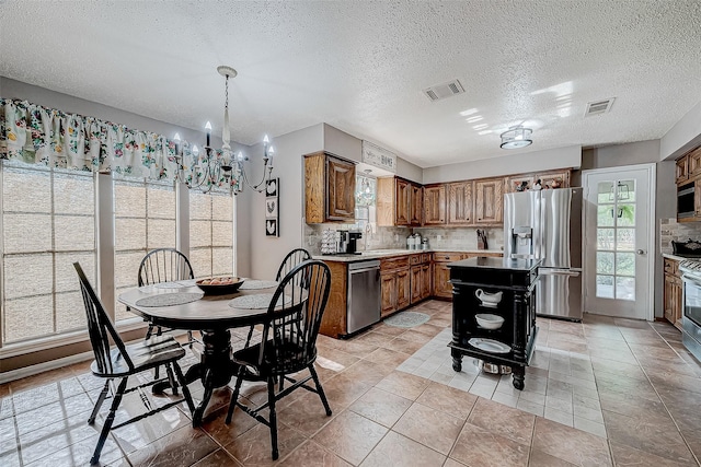 dining space featuring a chandelier, light tile patterned floors, a textured ceiling, and sink