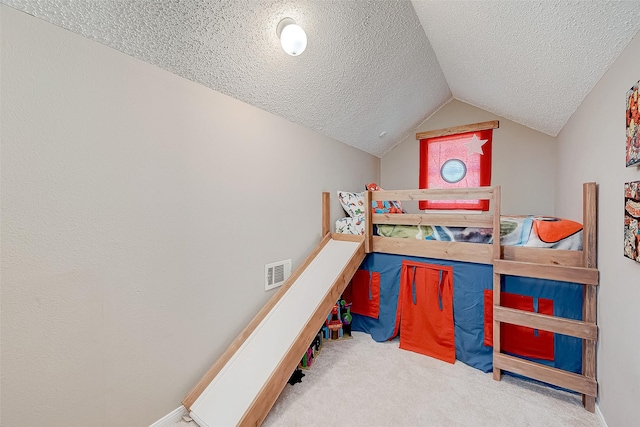 bedroom with a textured ceiling, carpet, and lofted ceiling