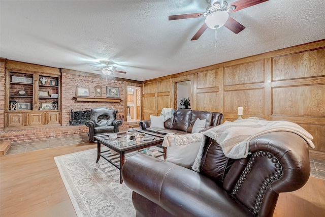 living room featuring a textured ceiling, light hardwood / wood-style flooring, and wooden walls