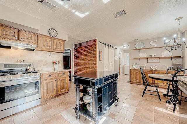 kitchen featuring gas stove, a notable chandelier, pendant lighting, a textured ceiling, and light tile patterned floors