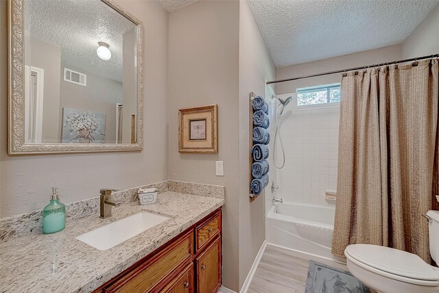 full bathroom with hardwood / wood-style floors, a textured ceiling, and shower / bath combination with curtain