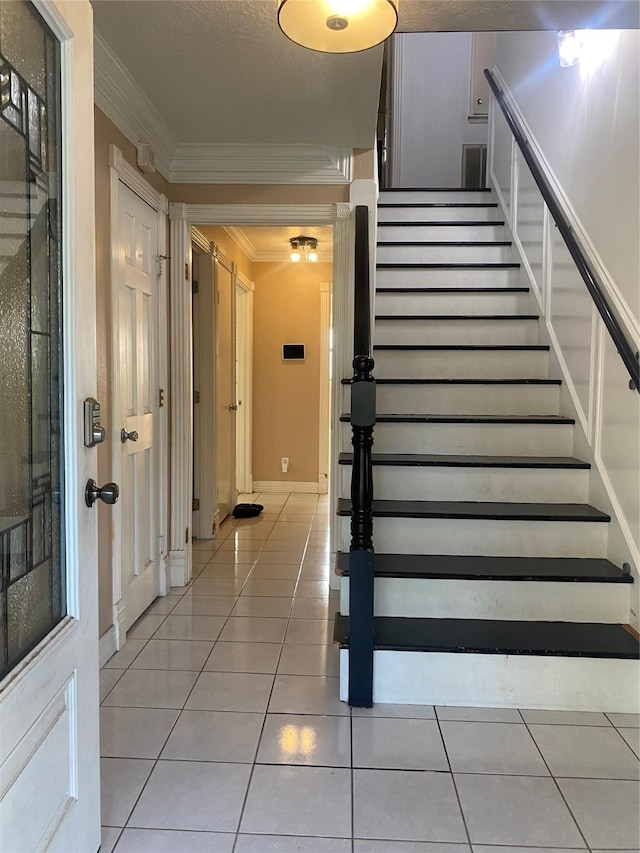 stairs with tile patterned floors and crown molding