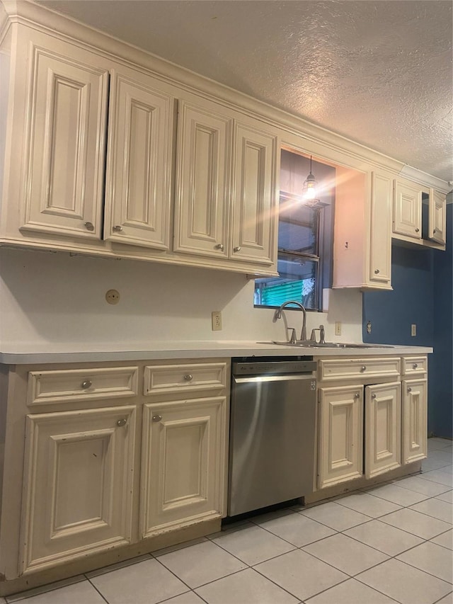 kitchen featuring dishwasher, sink, a textured ceiling, cream cabinetry, and light tile patterned flooring