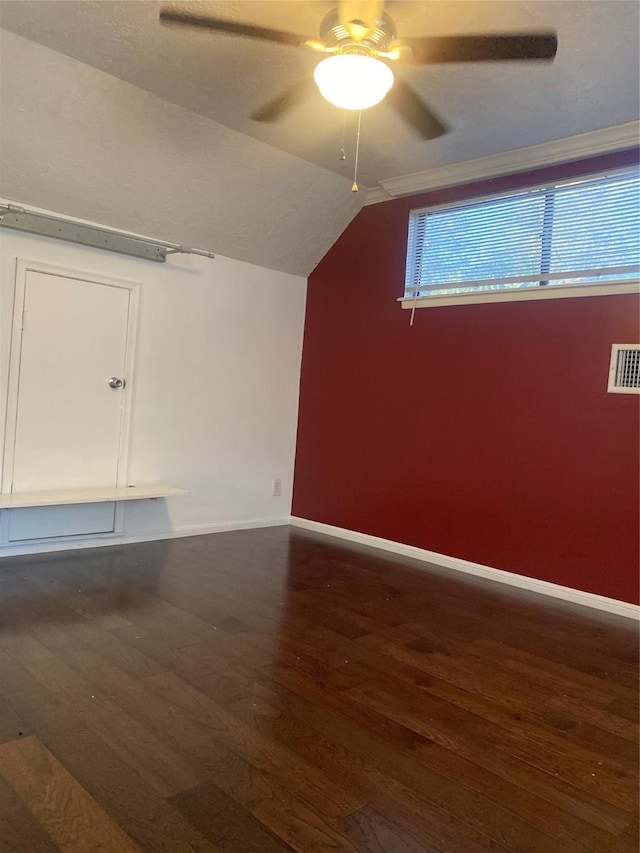 additional living space with dark hardwood / wood-style floors, vaulted ceiling, and ceiling fan