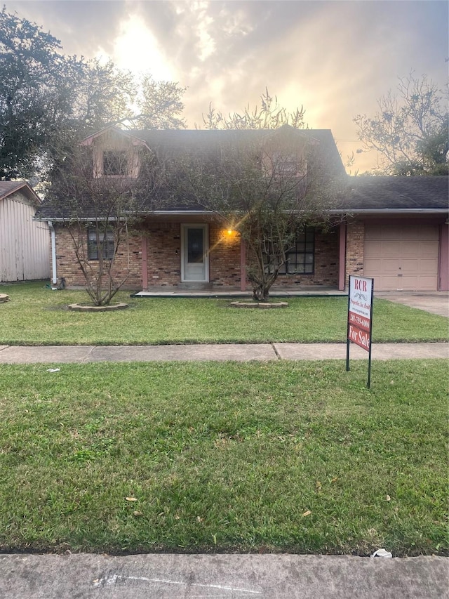 single story home with a garage and a lawn