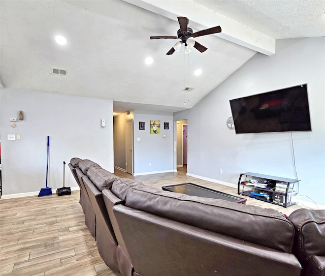 living room featuring a textured ceiling, ceiling fan, and vaulted ceiling with beams