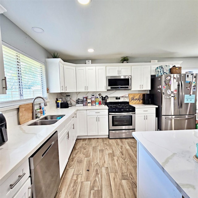 kitchen with sink, white cabinetry, backsplash, and appliances with stainless steel finishes