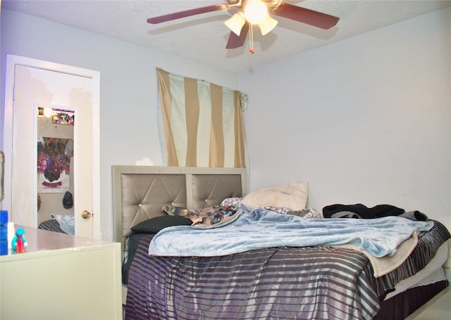 bedroom with a textured ceiling and ceiling fan