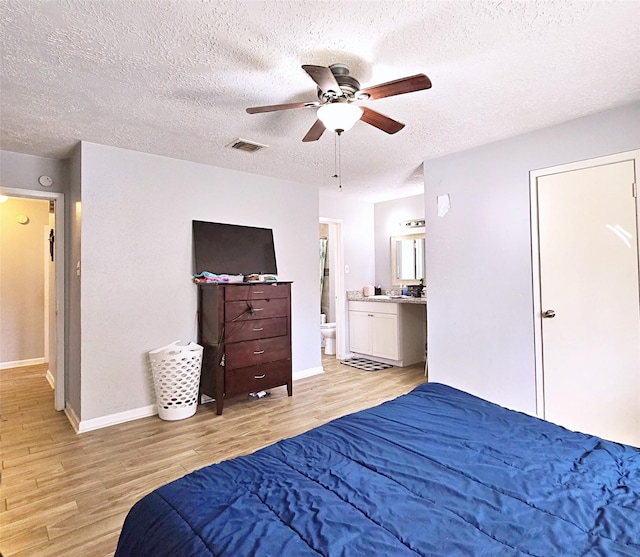 bedroom featuring connected bathroom, a textured ceiling, ceiling fan, and light hardwood / wood-style floors