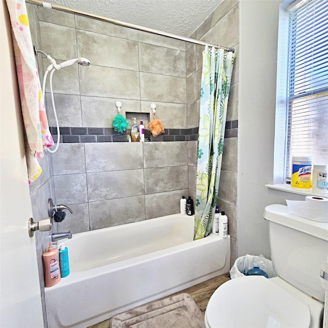 bathroom featuring a textured ceiling, toilet, and shower / bath combo