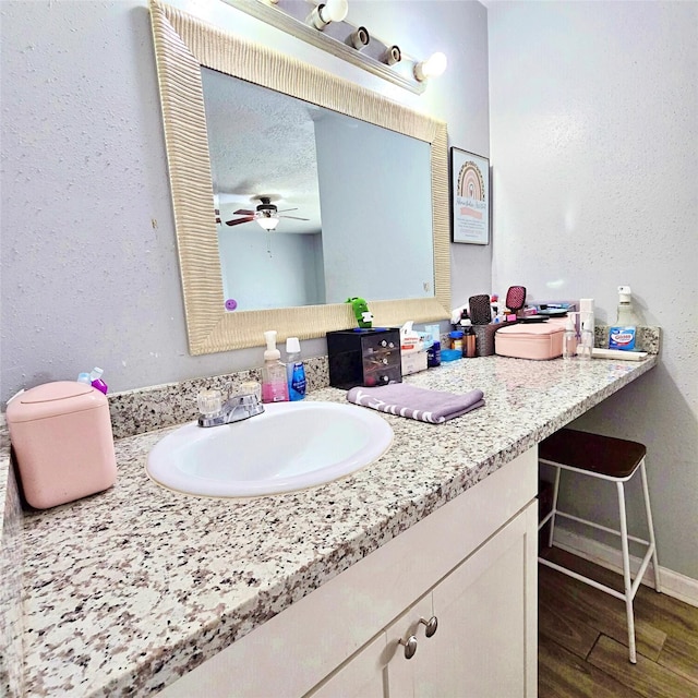 bathroom featuring hardwood / wood-style flooring, ceiling fan, and vanity