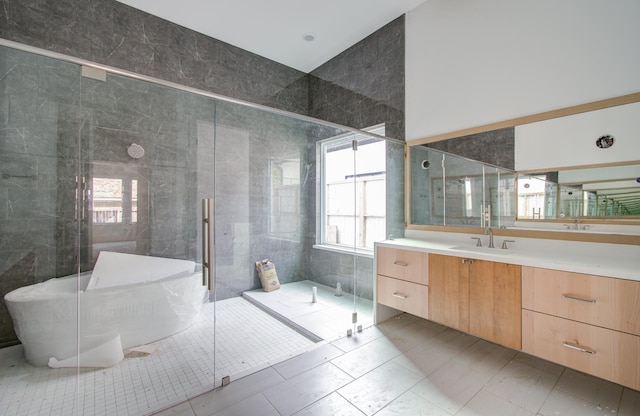 bathroom featuring tile patterned flooring, vanity, a shower with shower door, and tile walls