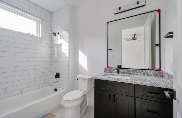 full bathroom with ceiling fan, vanity, tiled shower / bath combo, and toilet