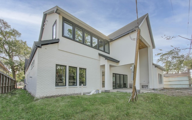 rear view of house with a lawn and a patio area