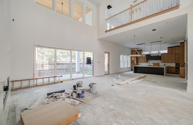 living room featuring a towering ceiling and sink