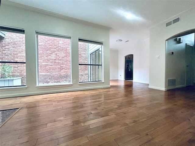 unfurnished living room with crown molding and dark hardwood / wood-style flooring