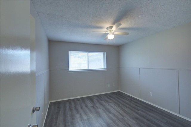 spare room featuring a textured ceiling, ceiling fan, and dark wood-type flooring