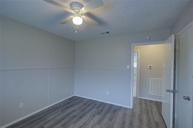 spare room with ceiling fan, a textured ceiling, and hardwood / wood-style flooring