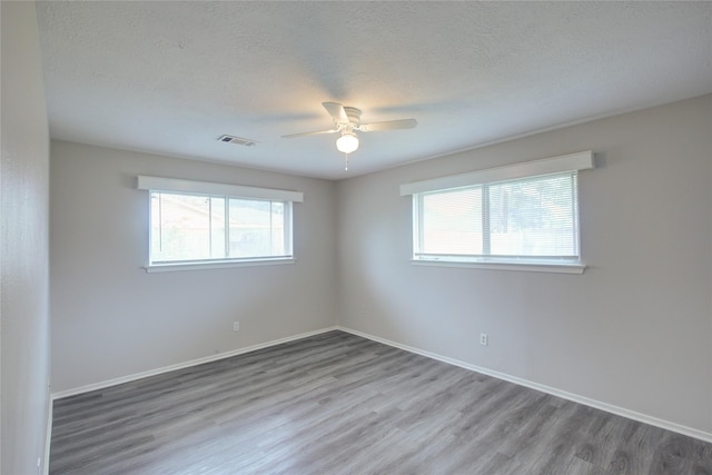 empty room with hardwood / wood-style flooring, ceiling fan, and a textured ceiling