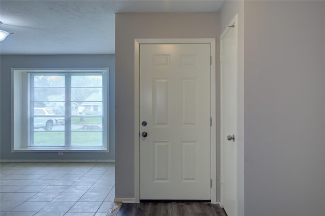 doorway featuring tile patterned floors and a textured ceiling